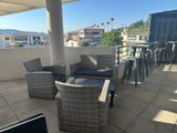 une terrasse avec des chaises en osier et une table