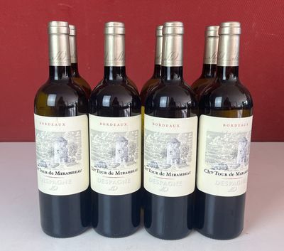quatre bouteilles de vin sont alignées sur une table