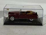 an old model of a red car in a clear case