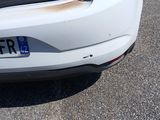 a white car with its hood open on the street