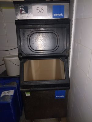 un poêle noir dans une petite pièce avec une poubelle bleue