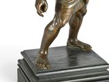 bronze statue of a man holding a tennis racquet on a marble base