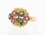 a close up of a gold ring with blue, pink and white stones