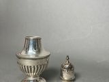 two silver vases sitting next to each other on a table