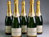 four bottles of champagne are lined up in a row