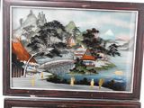 two framed paintings of asian landscapes on display