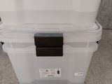a large white box with a black lid on the floor