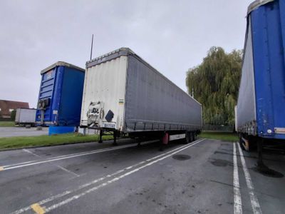 two semi trucks that are parked on the side of the road