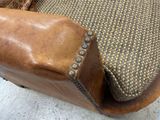 a brown leather chair with a brown seat and a brown cushion