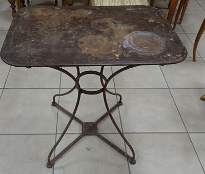 une petite table avec un plateau en métal posée sur un sol carrelé