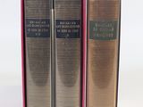 three books in a pink box on a white surface