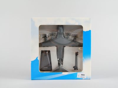 une boîte contenant un avion miniature, posée sur une surface blanche