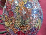 un œuf en verre coloré posé sur un socle, sur une table