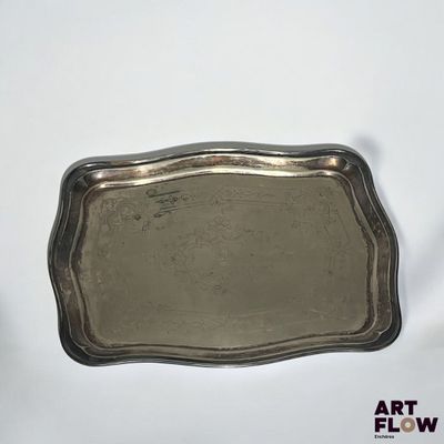 une image représentant un plateau en argent posé sur une surface blanche