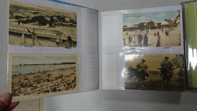 a person holding a book open to show pictures of people on the beach
