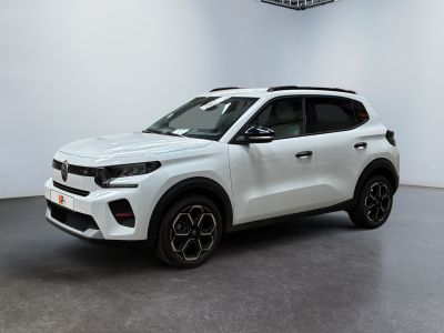 Le SUV blanc est garé dans une pièce blanche au sol noir.