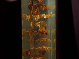 a glass vase filled with dried leaves on a table