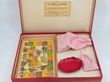 a red box with a pink glove and a book in it