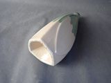 a small white vase with a green design on it