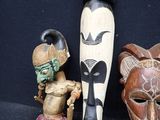 three wooden masks sitting next to each other on a black surface