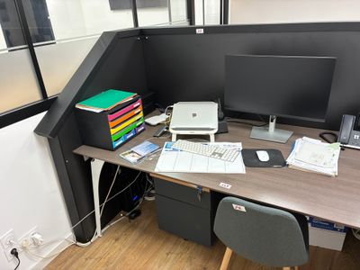 un bureau sur lequel se trouvent un ordinateur, une imprimante et d'autres fournitures de bureau