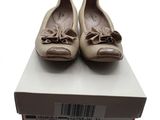 une paire de chaussures pour femme dans une boîte posée sur une surface blanche