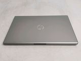 the laptop is sitting on a bed with a white sheet