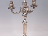 an antique silver plated candelab with three candles on it