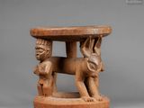 a small wooden table with an elephant and a man on it