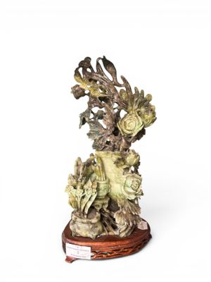 statue of a bird and flowers on a wooden base on a white background