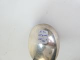 une cuillère en argent gravée, posée sur une table