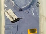 a blue shirt in a box with a tag on it