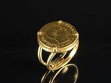 a gold ring with a coin in the middle of it