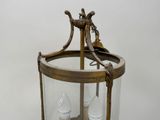 a glass lantern hanging from the ceiling on a table