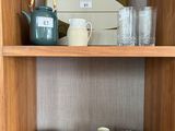 une étagère en bois sur laquelle sont posées une théière et des tasses