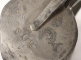 a silver spoon with a handle on a white surface