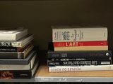 de nombreux livres sur une étagère, avec une pancarte posée dessus