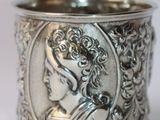 a close up of a silver cup with a lady on it