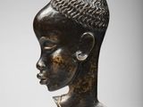 une tête de femme en bronze, avec une chaîne autour du cou