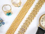 a lot of gold jewelry on a white surface