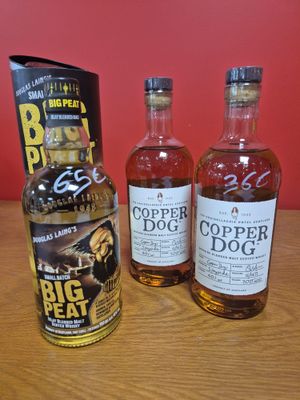 trois bouteilles de « Copper Dog » et un carton de bière posés sur une table