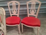 two chairs with red cushions and a white chair with a red cushion