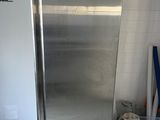 a stainless steel refrigerator in a room with a white tile floor