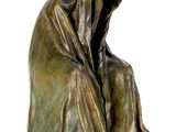 bronze sculpture of a woman sitting on her knees with a hood over her head