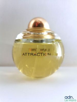 une photo d'un flacon de parfum posé sur une table