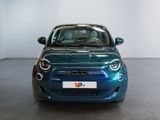 the small blue car is parked in the large room of the building