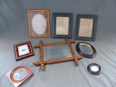 de nombreux cadres photo et un miroir posés sur un lit