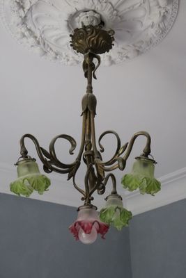 a chandelier with three flowers hanging from it ' s ceiling