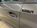 a silver car with a sticker on the door handle