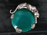 a ring with a green stone and a silver elephant on it